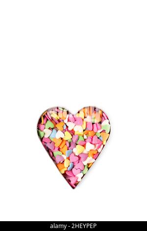 Multi-colored heart-shaped sprinkles pastry topping in heart form on white background, minimalistic saint valentine`s day greeting card Stock Photo